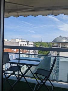 a table and two chairs sitting on a balcony at Superbe STUDIO (28m2) avec terrasse / vue TOUR EIFFEL / PUTEAUX in Puteaux