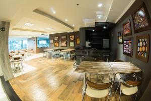 a restaurant with wooden tables and chairs in a room at Prix Hotel in Passo Fundo