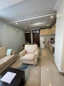 a living room with two couches and a kitchen at IZA Serene city centre apartments in Kigali