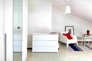 a room with a white dresser and a red chair at APPARTAMENTO SFERISTERIO in Macerata