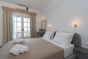 a bedroom with a large bed with towels on it at Astri Hotel in Neos Marmaras
