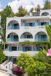 an apartment building with balconies and flowers at Astri Hotel in Neos Marmaras