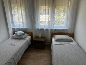twee bedden in een kamer met twee ramen bij Croatiaumag in Umag