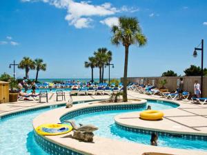 a swimming pool with people sitting on lounge chairs at a resort at Paradise Ocean View at Top Resort w Lazy River in Myrtle Beach