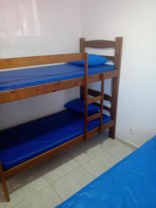two bunk beds in a room with blue sheets at Ed.fragatas residence in Bertioga