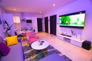 a living room with a couch and a tv at Piano and Gold at The Signature, Tetteh Quarshie in Accra +37 photos