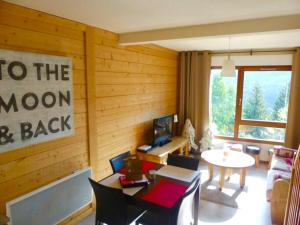 a living room with a wooden wall with a table and a television at L'entre 2 Lacs in Xonrupt-Longemer