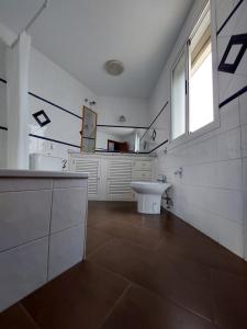 Un baño blanco con lavabo y ventana en Apartamento Artesanos Ronda, en Ronda 29 fotos más