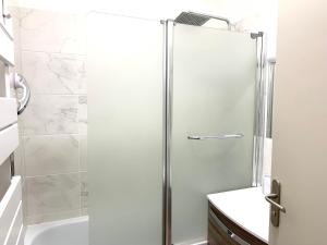 een douche met een glazen deur in de badkamer bij Appartement Les Halles 2, Climatisation, Terrasse, Garage in Narbonne