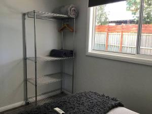 a room with three shelves in a room with a window at Magnolia Cottage in Coffs Harbour