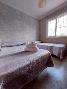 Dos camas en una habitación con dos ventanas. en Apartamento Artesanos Ronda, en Ronda