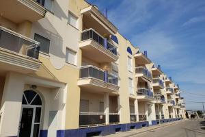 un edificio de apartamentos con balcones azules en una calle en Apartamento HOUSE FRANMAR, en Sant Jaume d'Enveja