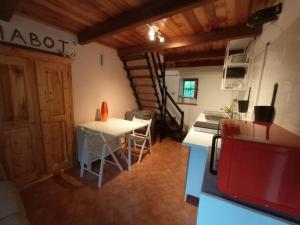 a room with a table and a kitchen with a staircase at Il Ciabot del Bosco in Frassino