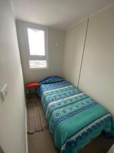 a small bedroom with a bed and a window at Dpto Full Equipado ,6 Pers ,2 Baños + Estacionamiento in Puerto Montt