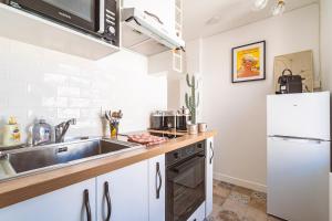 a small kitchen with a sink and a refrigerator at ExploreReims - California Dream studio proche gare/centre in Reims