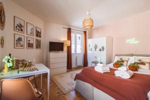 a bedroom with a bed with a desk and a television at ExploreReims - California Dream studio proche gare/centre in Reims