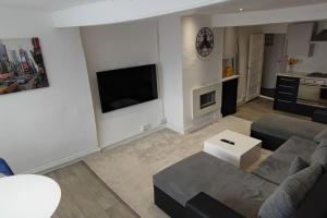 - un salon avec un canapé et une télévision dans l'établissement Cosy 1 Bedroom Flat in Southam, à Southam