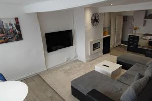 a living room with a couch and a tv at Cosy 1 Bedroom Flat in Southam in Southam