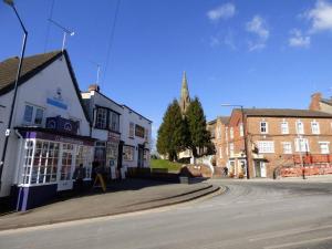 an empty street in a small town with buildings at Cosy 1 Bedroom Flat in Southam in Southam