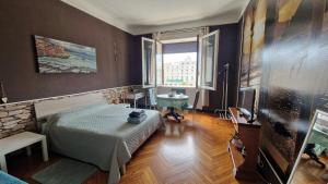 ジェノヴァにあるB&B Piazza della Vittoriaのベッドルーム1室(ベッド1台、テーブル、窓付)