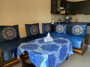 ein blaues Bett mit einem Tisch in einem Zimmer in der Unterkunft Perle sur la mer in Mohammedia