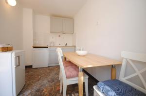 una pequeña cocina con mesa de madera y sillas en Rooms Dilk en Vis