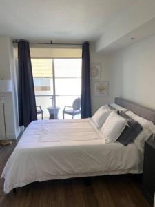 Un dormitorio con una cama grande y una ventana en The Palomino - Modern, Stylish, Secure Entry, Spacious Condo with 2 Master Bedrooms, WLK to Pier en Los Ángeles