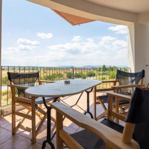 a table and chairs on a balcony with a view at Elia mini suites 5 in Larisa