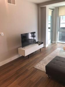 a living room with a large flat screen tv at The Palomino - Modern, Stylish, Secure Entry, Spacious Condo with 2 Master Bedrooms, WLK to Pier in Los Angeles
