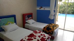 sypialnia z 2 łóżkami i oknem w obiekcie l'avocatier w mieście Kenitra