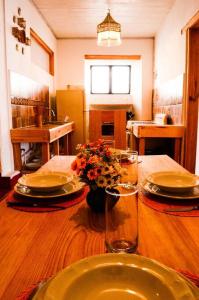 a wooden table with plates and glasses and flowers on it at En el Corazón de Valle, Casa Luz María. in Valle de Bravo