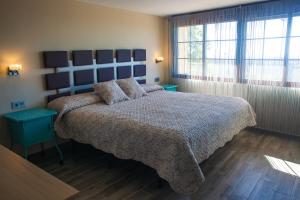 a bedroom with a large bed with a blue headboard at Alojamiento Nohal in La Iruela
