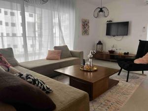 a living room with a couch and a coffee table at New apt with a big balcony at karmei gat in Qiryat Gat