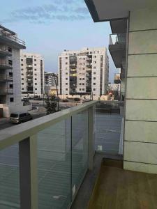 a balcony with a view of a city with tall buildings at New apt with a big balcony at karmei gat in Qiryat Gat