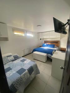 um quarto com duas camas e uma televisão em Hostal Florecer em Angol