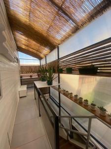 a room with tables and potted plants and a ceiling at Hostal Florecer in Angol