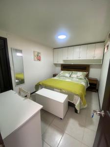 a small bedroom with a bed with a yellow blanket at Hostal Florecer in Angol +8 photos