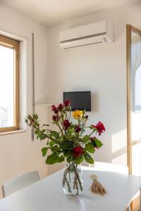 a vase filled with flowers sitting on a table at BED BIANCANEVE Attico in Villanova di Ostuni