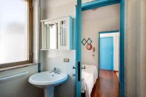 bagno con lavandino, servizi igienici e specchio di BED BIANCANEVE Attico a Villanova