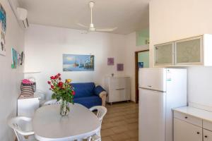 a small kitchen with a table and a refrigerator at BED BIANCANEVE Miniappartamento in Villanova di Ostuni