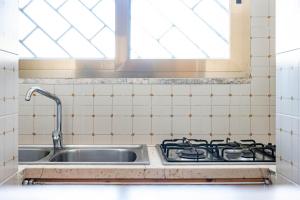 a kitchen sink with a stove and a window at BED BIANCANEVE Miniappartamento in Villanova di Ostuni +42 photos