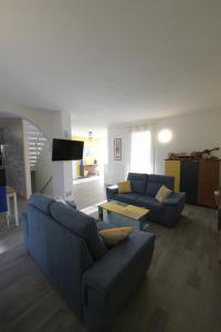 sala de estar con 2 sofás azules y TV en TerrazzaPonente, en Monte San Pietro
