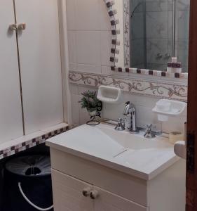 uma casa de banho branca com um lavatório e um espelho em MAGUI CONCEPCION DEL URUGUAY em Concepción del Uruguay