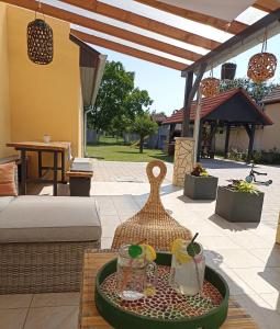 eine Terrasse mit einem Tisch und Getränken darauf in der Unterkunft MeLuIs in Balatonkeresztúr