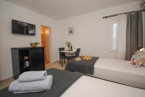 ein Hotelzimmer mit 2 Betten und einem Tisch in der Unterkunft Rooms Dilk in Vis