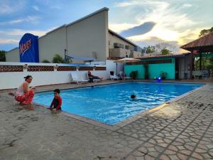 una mujer y un niño jugando en una piscina en Hotel Coronado Inn, en Playa Coronado