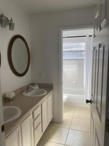 a bathroom with two sinks and a mirror at Home from Home 5 bedroom villa in Davenport