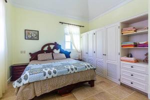 a bedroom with a large bed and white cabinets at Victorian Condominium, Cabarete! in Cabarete