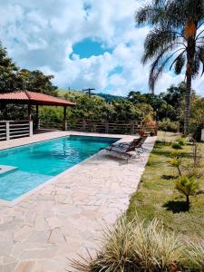 a swimming pool with a bench and a gazebo at Chácara Rancho Imperial - Socorro - SP - Piscina, Churrasqueira, Forno à Lenha, Campo de Futebol e uma linda Vista para a Montanha! in Socorro
