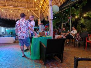 un hombre de pie junto a una mesa con una mesa verde en Hotel Coronado Inn en Playa Coronado